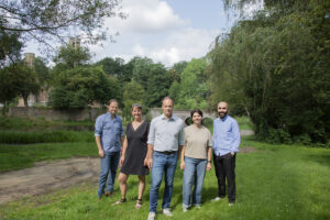 Team poseert voor een foto buiten, genietend van de natuur en samenwerking.