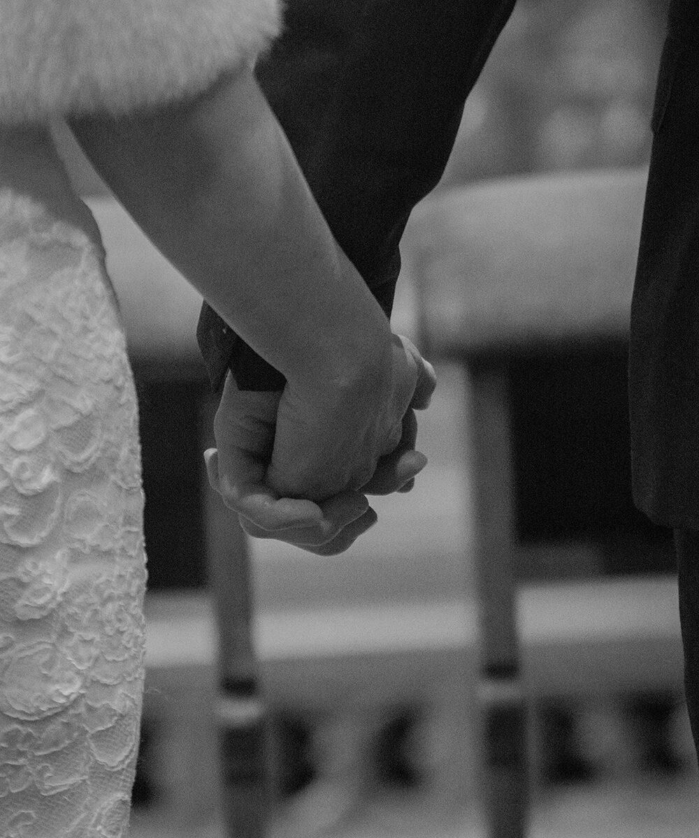 Koppel hand in hand tijdens een ceremonie "huwelijk in Koningshooikt".