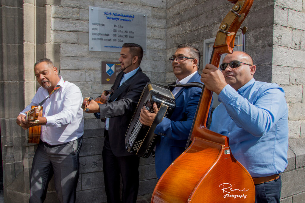 Muziekgroep treedt op nabij Sint-Nicolaaskerk, mogelijk bij een huwelijk.