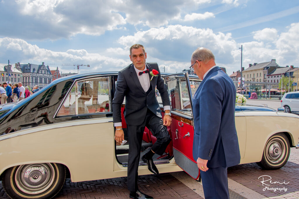 Man in pak verlaat klassieke auto in Sint-Niklaas-huwelijk