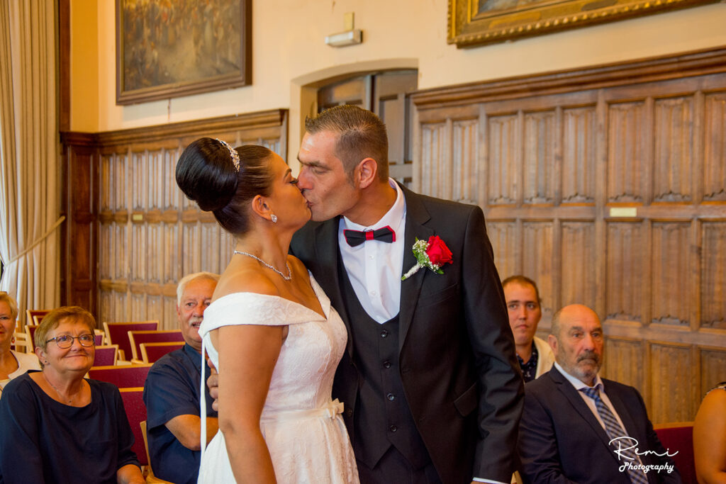 Jonggehuwden delen een kus bij een huwelijk in Sint-Niklaas