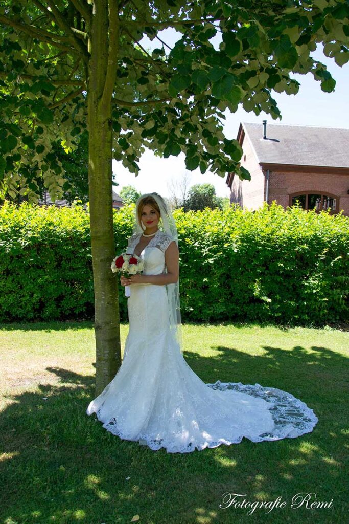 Bruid in trouwjurk op Strijboshof Kalmthout, bloemen vasthoudend
