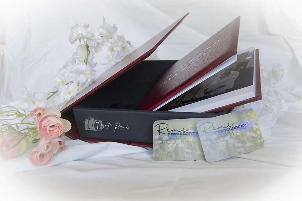 Rood leren fotoalbum met visitekaartjes en bloemen.