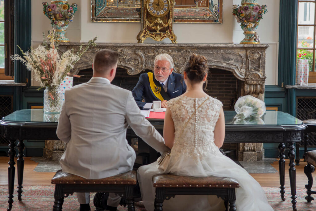 Huwelijk in Lier: Bruid en bruidegom tijdens een huwelijksceremonie met de ambtenaar van de burgerlijke stand