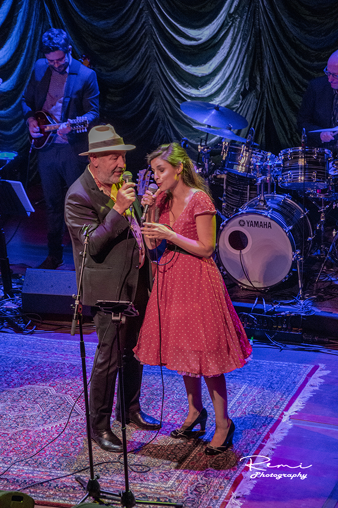 Jazzband die livemuziek speelt: mannelijke zanger, vrouwelijke zanger en band op het podium.