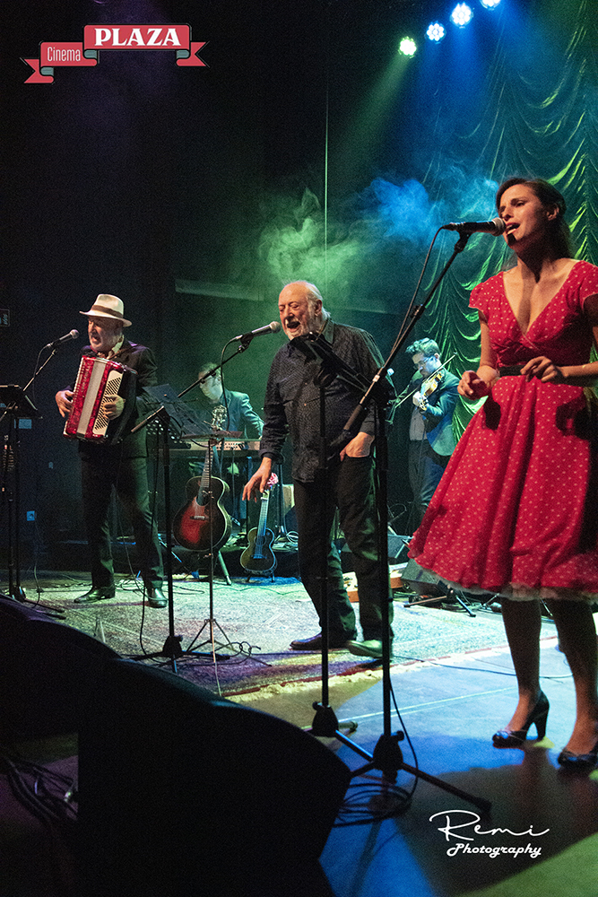 Band geeft een liveconcert in Cinema Plaza, met zanger, accordeon en andere muzikanten.