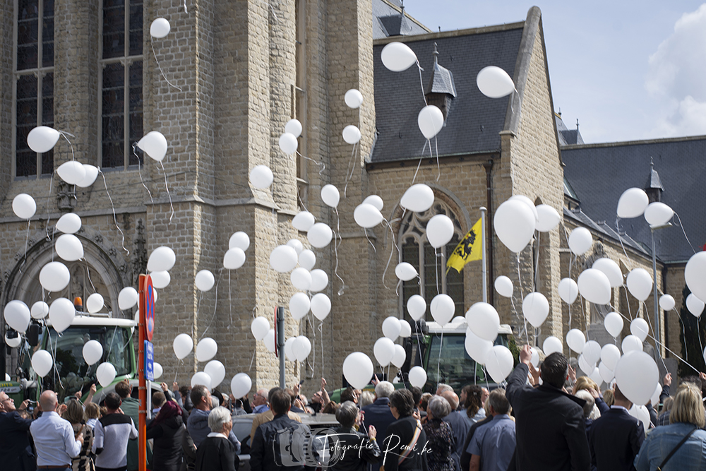 Mensen laten witte ballonnen los tijdens een begrafenisceremonie in België