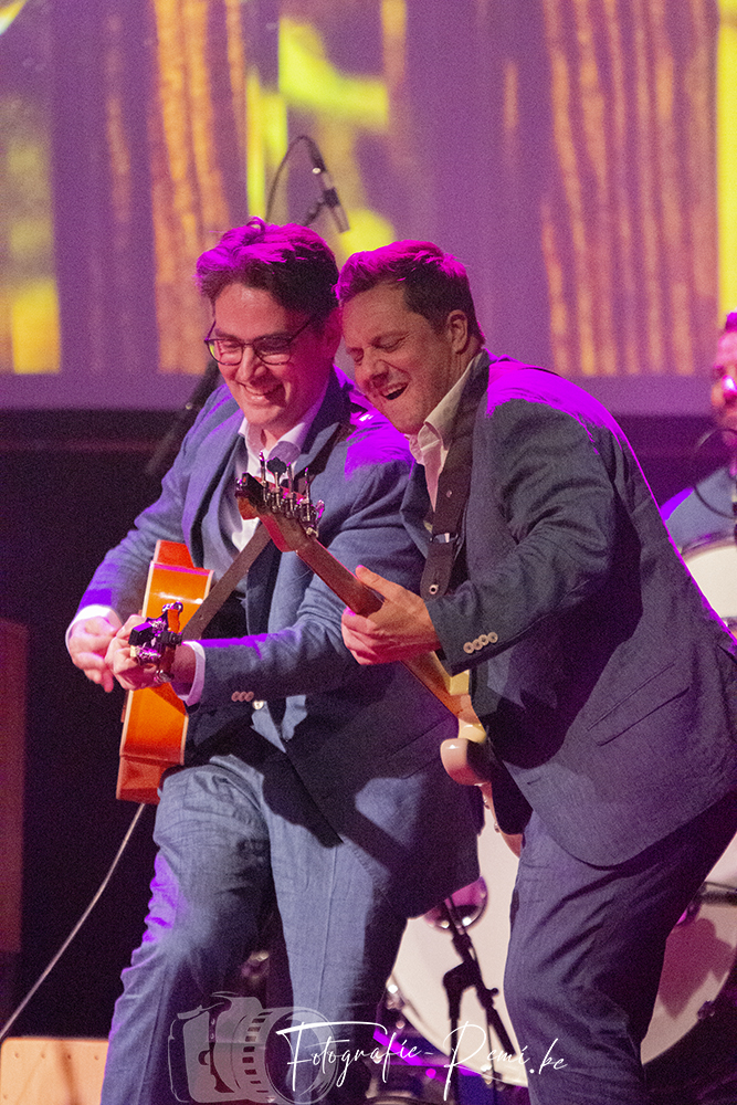 De leden van de Bonanzas-band spelen gitaar op het podium en lachen